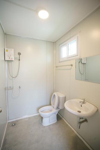 a bathroom with a toilet and a sink at Barn Sampran Resort บ้านสามพรานรีสอร์ท in Nakhon Pathom
