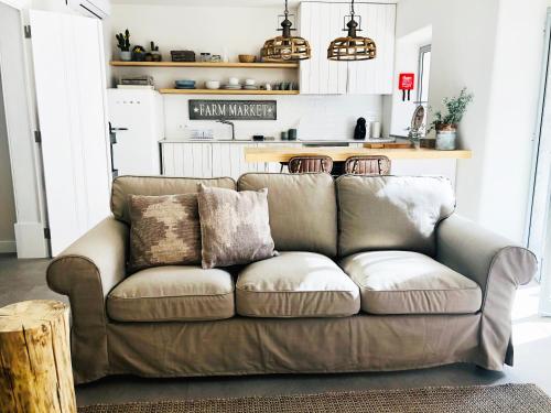 un sofá marrón en una sala de estar con cocina en Charming Design House in Montijo, Casa 41 en Montijo