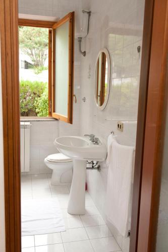 a bathroom with a sink and a toilet and a mirror at Elena Residence in Torchiara