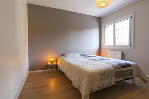 une chambre avec un grand lit et une fenêtre dans l'établissement Azur Bleu 4 étoiles Annecy centre-ville et lac lumineux, à Annecy