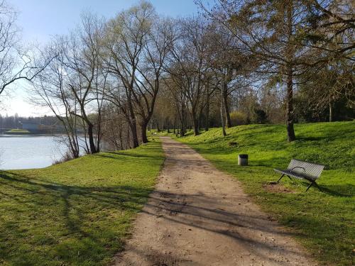 a dirt road next to a park with a bench at La maison Virginie 1 à 2 pers charmant central-parking gratuit- linge- fibre- proximité port lac canal piscine in Montargis