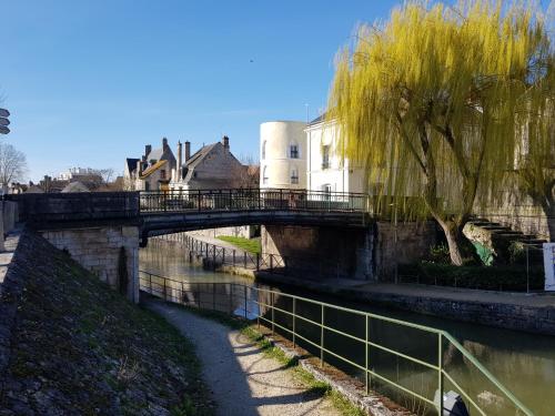 a bridge over a river with buildings and trees at La maison Virginie 1 à 2 pers charmant central-parking gratuit- linge- fibre- proximité port lac canal piscine in Montargis