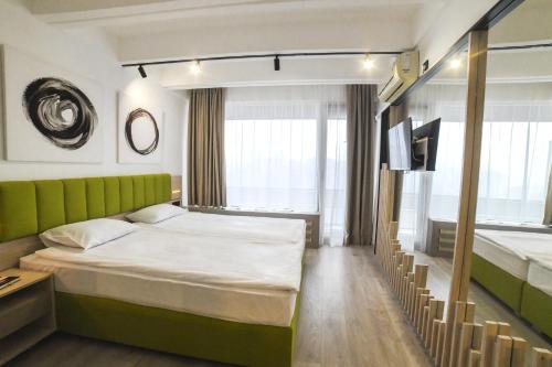 um quarto de hotel com duas camas e uma televisão em Medical and Spa Centre Merkur em Vrnjačka Banja