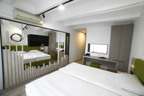 a hotel room with two beds and a mirror at Medical and Spa Centre Merkur in Vrnjačka Banja