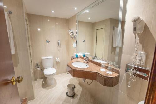 a bathroom with a sink and a toilet and a mirror at Sunrise Holidays Resort -Adults Only in Hurghada