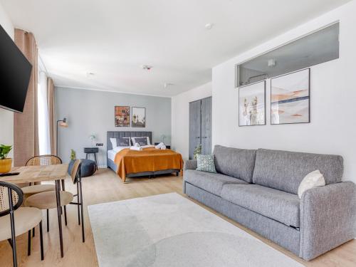 a living room with a couch and a bed at Limehome Münster Von-Steuben-Str - Digital Access in Münster