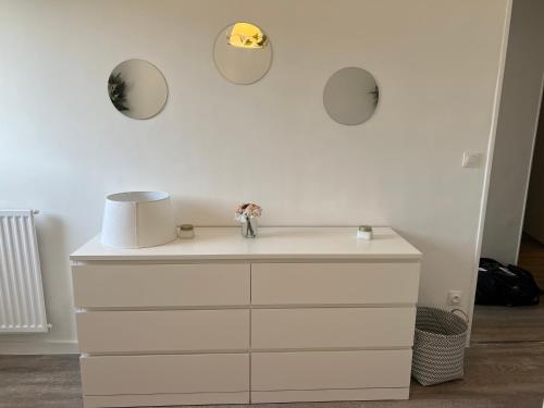 une commode blanche avec trois miroirs sur le mur dans l'établissement Superbe appartement dans les calanques, à Marseille
