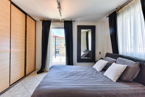 ein Schlafzimmer mit einem Bett und einem großen Fenster in der Unterkunft Happyfew Le Lucia in Nizza
