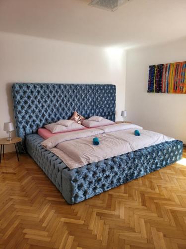 a large bed with a blue headboard in a room at Vila Quantum Bohemia in Vyšší Brod