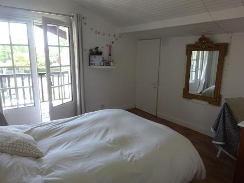 1 dormitorio con 1 cama blanca grande y espejo en Maison familiale Landaise pour 2 couples, enfants, en Azur