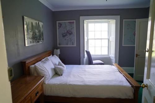 a bedroom with a bed and a window at Ballachulish House Apartment in Ballachulish