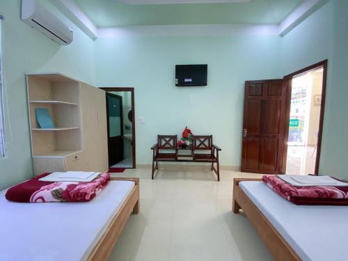 a bedroom with two beds and a tv on the wall at MINH THU MOTEL in An Bình (1)