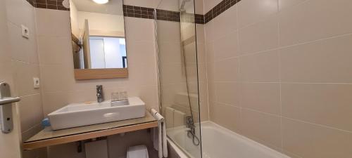 a bathroom with a sink and a shower and a tub at Residence Syracuse in Villeneuve-Loubet