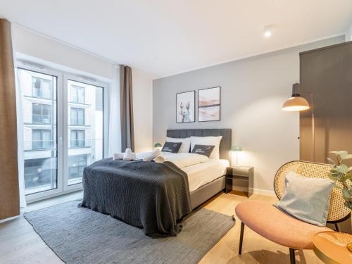 a bedroom with a bed and a large window at Limehome Münster Von-Steuben-Str - Digital Access in Münster