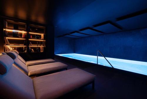 ein blaues Zimmer mit einer Badewanne und einer Bank. in der Unterkunft Harmon House in Brüssel