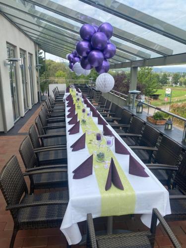 a long table with purple and purple balloons on it at M13 Hotel in Riol