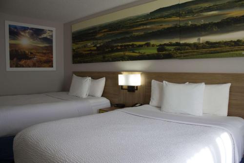 a hotel room with two beds and a painting on the wall at Days Inn by Wyndham Colby in Colby