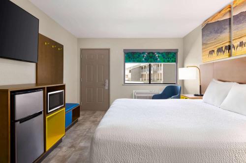 a hotel room with a bed and a tv at Days Inn by Wyndham Ruidoso Downs in Ruidoso Downs