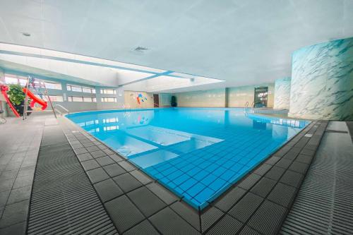 a large swimming pool in a large building at Ramada Plaza Pudong Shanghai in Shanghai