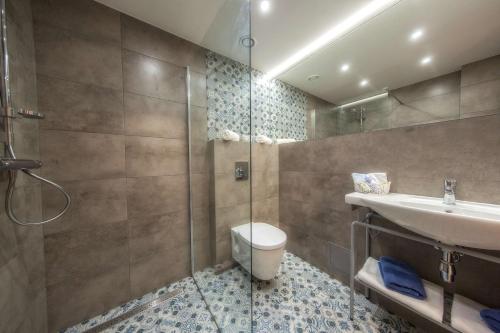 a bathroom with a shower and a sink and a toilet at Hotel Paryski Art & Business Zakopane - Basen Jacuzzi Sauna Małpi Gaj in Zakopane