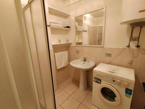 a small bathroom with a sink and a washing machine at Angy Central Apartament in Aosta