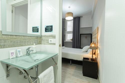 baño con lavabo y cama en Easy Sants by Bossh!, en Barcelona