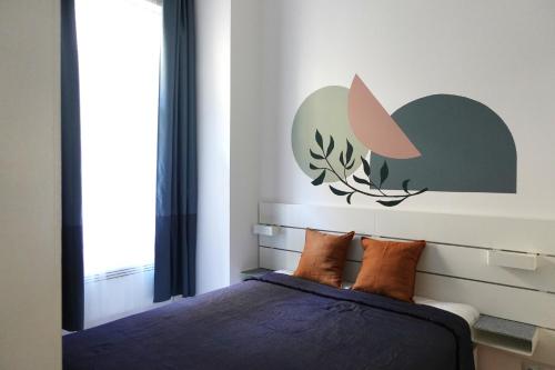 Schlafzimmer mit einem Bett mit einem Kopfteil und einem Fenster in der Unterkunft BpR Pastellion Art Home in Buda in Budapest