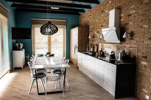 a kitchen with a dining table and a brick wall at Willa Hel in Hel