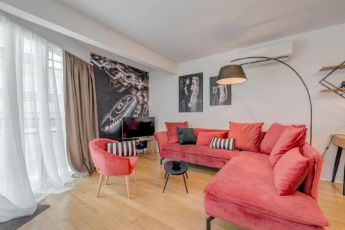a living room with a red couch and two chairs at Paparazzi Apartment in Split