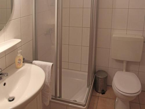 e bagno con doccia, servizi igienici e lavandino. di Ferienhaus Nr 38, Kategorie Komfort, Feriendorf Hochbergle, Allgäu a Bichel