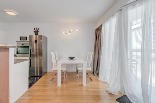 a white table and chairs in a kitchen with a window at Paparazzi Apartment in Split