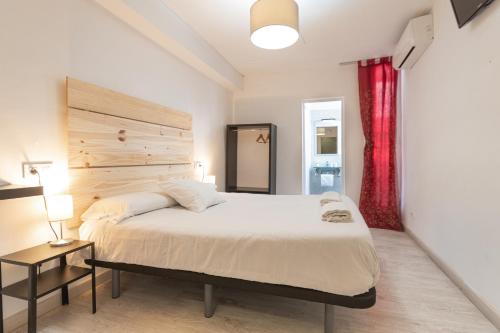 ein Schlafzimmer mit einem großen Bett und einem roten Vorhang in der Unterkunft Easy Sants by Bossh! in Barcelona