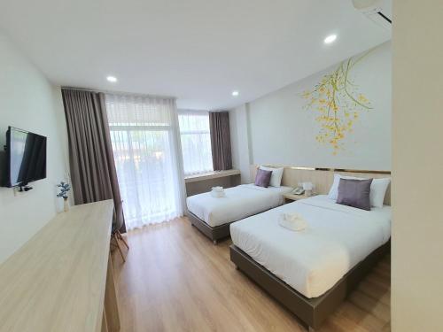 a hotel room with two beds and a television at Lueangchan Orchid Hotel in Chanthaburi