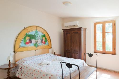 1 dormitorio con cama y vidriera en Agriturismo IL GREPPO, en Abbadia di Montepulciano