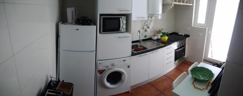 a kitchen with a refrigerator and a washing machine at Casa Mateus - Colares, Parque Natural Sintra Cascais in Sintra