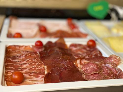 a tray of meat and tomatoes on a table at GAIA Hotel Basel - the sustainable 4 star hotel in Basel