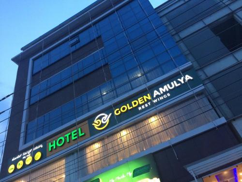 a hotel sign on the side of a building at GOLDEN AMULYA REST WINGS in Yelahanka