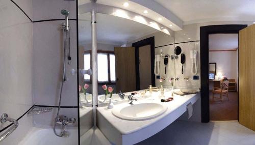 a bathroom with a sink and a shower at Hotel Des Geneys in Bardonecchia