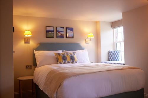 um quarto com uma cama com 2 candeeiros e uma janela em The Bell & Crown em Zeals