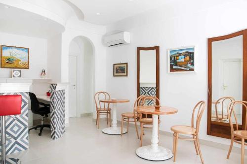 アナカプリにあるBeB Casa Romanoの椅子、テーブル、鏡付きの部屋