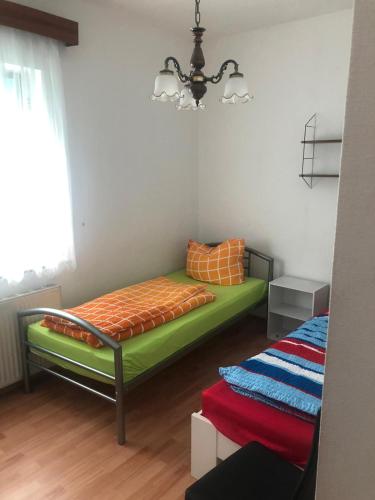 a bedroom with a bed with an orange and green mattress at Schöner Wohnen in Senzig bei Berlin 2 in Senzig
