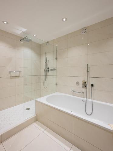 a white bathroom with a tub and a shower at GAIA Hotel Basel - the sustainable 4 star hotel in Basel