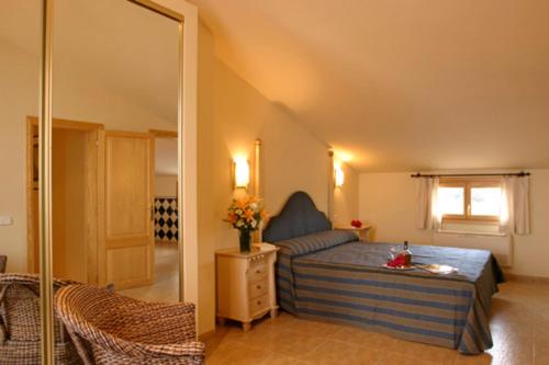 een slaapkamer met een bed en een spiegel bij Balcón d'es Trenc in Sa Ràpita