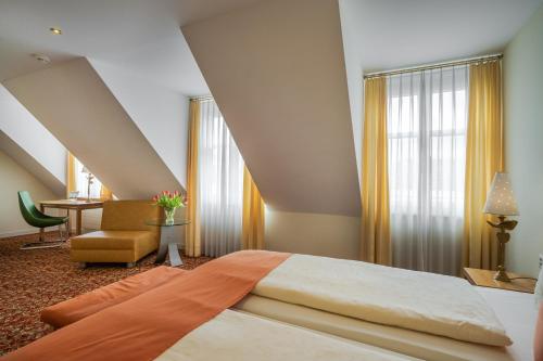 a bedroom with a large bed and a chair at GAIA Hotel Basel - the sustainable 4 star hotel in Basel