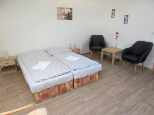 a bed in a room with two chairs and a bed sidx sidx sidx at Penzion U Hradeb in Znojmo