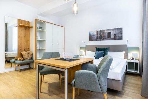 a bedroom with a bed and a table and chairs at Ferienapartments am Krusespeicher Ferienapartments am Krusespeicher 0-01 in Wismar