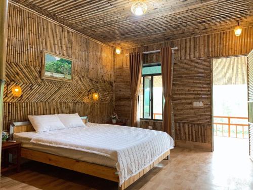 a bedroom with a bed in a wooden wall at Trang An Homestay in Ninh Binh
