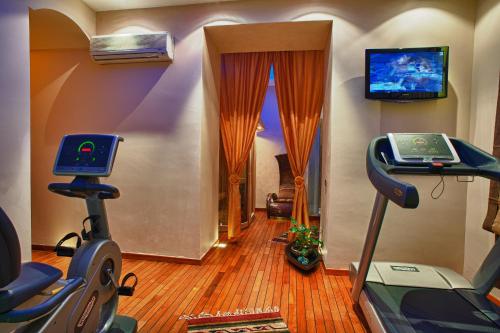 a room with a gym with a treadmill and a television at Grand Hotel Wagner in Palermo