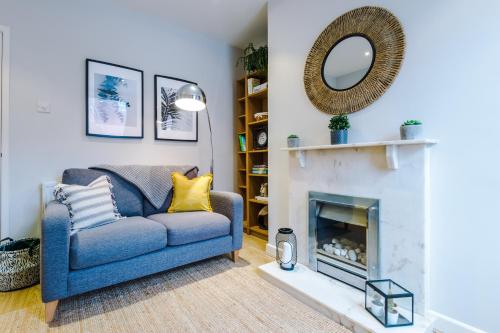ein Wohnzimmer mit einem blauen Sofa und einem Kamin in der Unterkunft Quaint 2 Bedroom Chester City Cottage in Chester