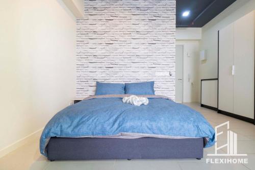 a bedroom with a blue bed and a brick wall at 9am-5pm, SAME DAY CHECK IN AND CHECK OUT, Work from Home, Comfy & Quiet Tamarind Suites-Cyberjaya by Flexihome-MY, in Cyberjaya
